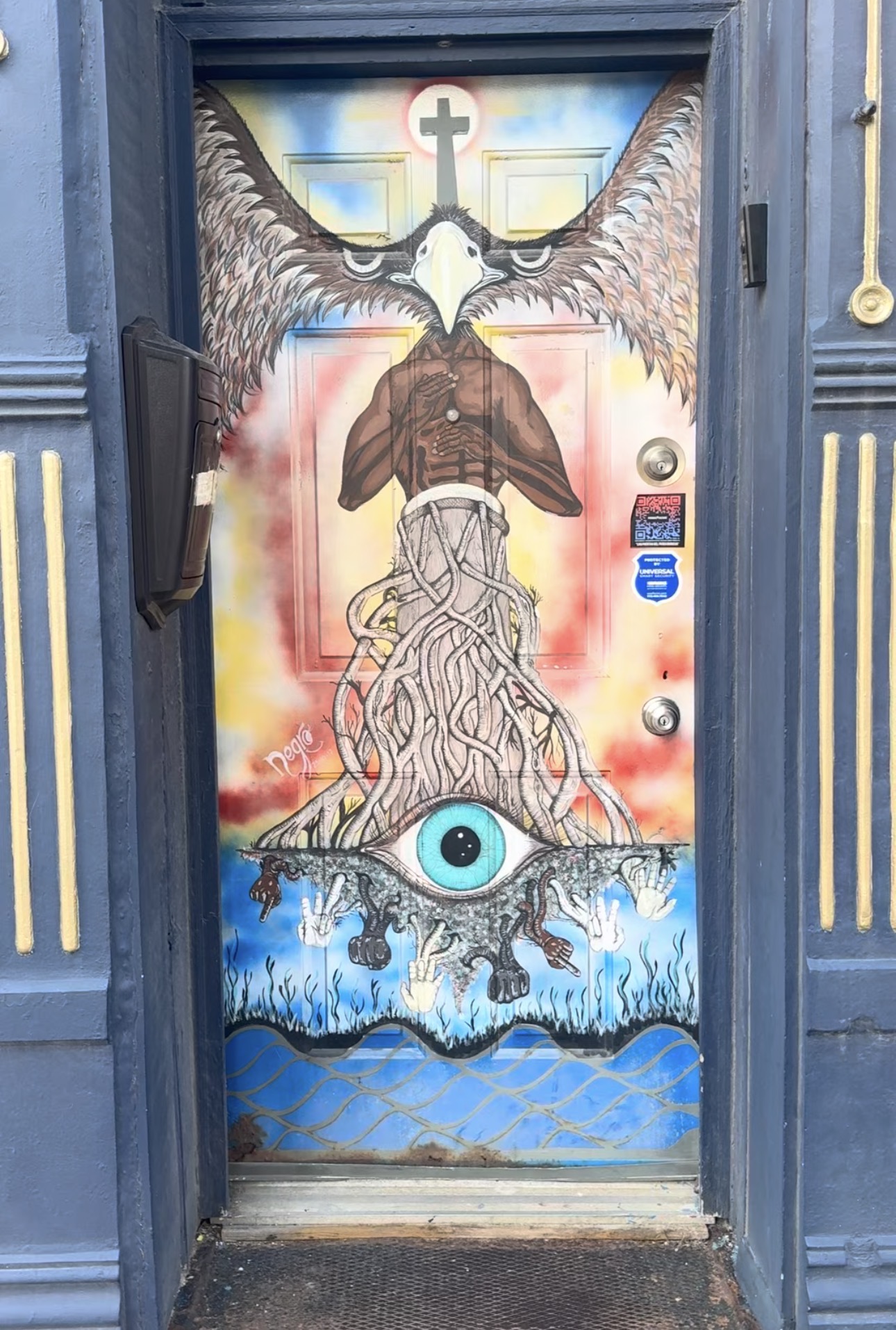 Arte pintado sobre una puerta en Chicago, con un ojo, raíces, alas y palabras "Negro."