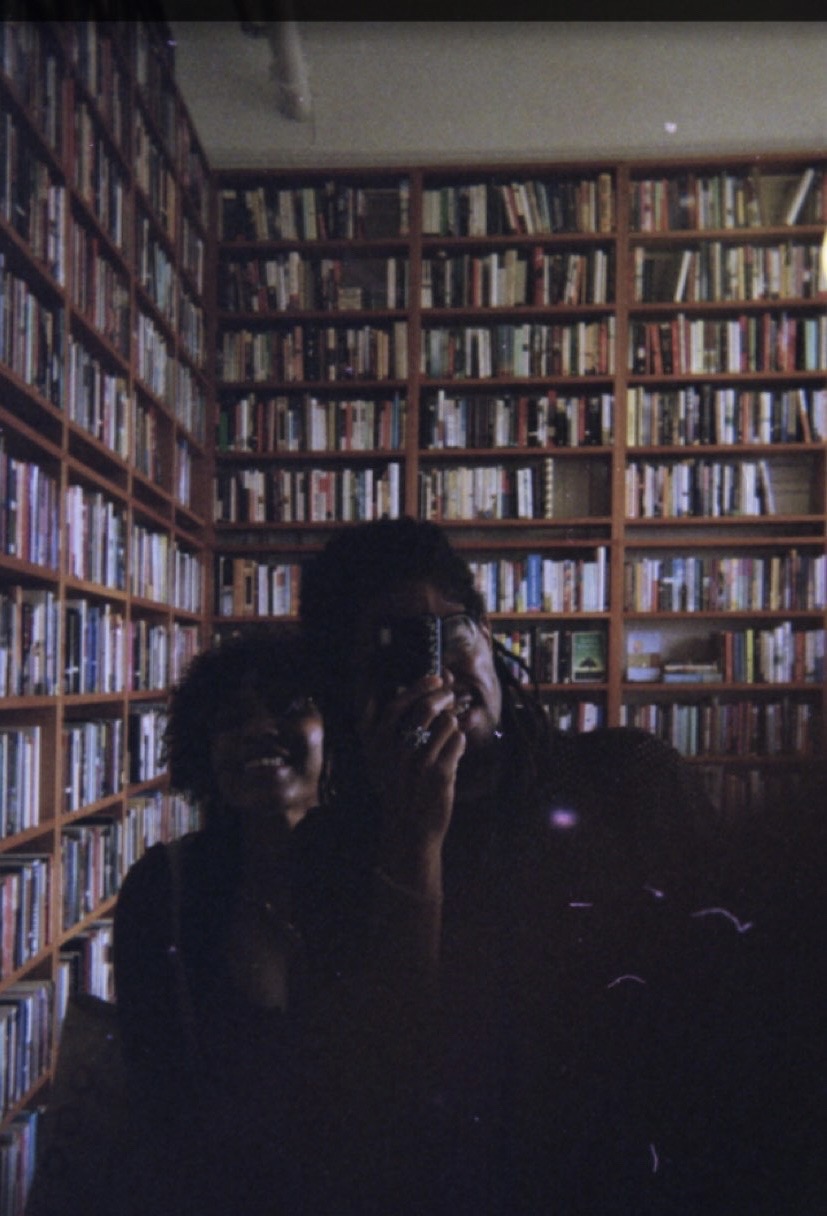 Rod & Natasha reflected in a library mirror, photographed by Rod on point-and-shoot camera